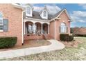 Inviting front porch with rocking chairs, columns, and a welcoming entrance to the brick home at 123 Wheatridge Dr, Statesville, NC 28625