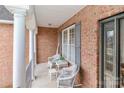 Cozy covered porch featuring brick columns, wicker seating, and stylish accents at 123 Wheatridge Dr, Statesville, NC 28625