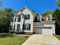 Traditional two-story home with a two-car garage, complemented by a well-manicured front lawn at 12403 Panthersville Dr, Charlotte, NC 28269
