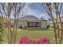 Large backyard with a screened deck, lush green grass, and mature trees at 14830 Creeks Edge Dr, Charlotte, NC 28278