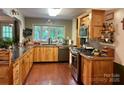 Spacious kitchen featuring light wood cabinetry, hardwood floors, stainless steel appliances, and a large window at 1496 Givens St, Hickory, NC 28602