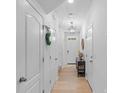 Inviting hallway with light wood floors, white trim, and ample storage at 3306 Yarmouth Ln, Gastonia, NC 28056