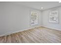 Spacious bedroom with wood-look flooring and large windows with lots of light at 4913 Seacroft Rd, Charlotte, NC 28210