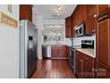 A modern kitchen with stainless steel appliances, cherry cabinets, and granite countertops at 515 Blue Crush Ct, Rock Hill, SC 29732