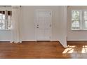 Inviting entryway showcasing gleaming hardwood floors, a bright window, and a solid white door at 5300 Buckingham Dr, Charlotte, NC 28209
