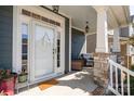 Inviting front porch with stone pillars, white railings, and a cozy seating area with a welcome sign at 6187 Cloverdale Dr, Tega Cay, SC 29708