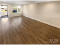 Spacious, empty living room showcasing new flooring and large windows at 6436 Old Pineville Rd # C, Charlotte, NC 28217