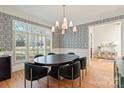Dining room featuring elegant wallpaper, modern lighting, and large windows with natural light at 7924 Pemswood St, Charlotte, NC 28277