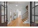 Inviting foyer with hardwood floors, staircase, and an open view into the living spaces at 7924 Pemswood St, Charlotte, NC 28277