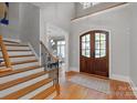 Bright foyer with hardwood floors, staircase, and arched entryway leading to the dining room at 7924 Pemswood St, Charlotte, NC 28277