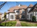 Beautiful home showcasing a stone facade, well-kept lawn, and a welcoming walkway to the front entrance at 7924 Pemswood St, Charlotte, NC 28277
