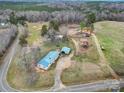 Sprawling property with blue-roofed home, multiple outbuildings, and vast wooded and cleared acreage at 836 Love Rd, Blackstock, SC 29014