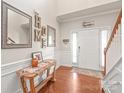 Bright foyer with wainscoting, decorative mirrors and an entry table next to the front door at 8513 Loxton Cir, Charlotte, NC 28214