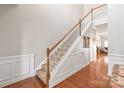 Bright staircase featuring hardwood floors, white trim, decorative molding and a wooden handrail at 8513 Loxton Cir, Charlotte, NC 28214