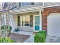 Inviting front entrance with a blue door, landscaped shrubbery, and one car garage at 8929 Bryant Field Cir, Charlotte, NC 28277
