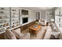 Bright, staged living room with fireplace, built-in shelves, hardwood floors, and neutral-toned furniture at 924 Springdale Ln, Gastonia, NC 28052