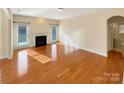 Spacious living room featuring gleaming hardwood floors and a cozy fireplace at 9503 Rocky Spring Nw Ct, Concord, NC 28027