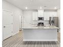 Bright kitchen features an island with granite counters and modern stainless steel appliances at 114 Ciara Pl # B, Mooresville, NC 28117