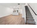 A light-filled open floor plan showcases the kitchen, living, and stairwell with a wooden floor and neutral walls at 114 Ciara Pl # C, Mooresville, NC 28117