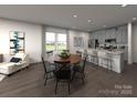 Open-concept living and dining area with a kitchen island, dining table, and modern decor at 114 Ciara Pl # C, Mooresville, NC 28117