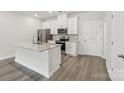 Bright kitchen with white cabinets, stainless steel appliances, and a center island with a granite countertop at 114 Ciara Pl # E, Mooresville, NC 28117