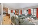 Spacious living room with a large green sectional sofa, wood floors, and bright lighting at 121 Inlet Point Dr, Tega Cay, SC 29708