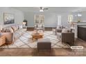 Bright living room featuring contemporary furnishings, hardwood floors, and large windows at 121 Woodbridge Cir, Mount Holly, NC 28120