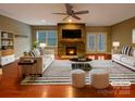 Bright living room featuring a stone fireplace, ceiling fan, and stylish furniture at 13217 Reunion St, Charlotte, NC 28278