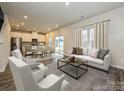 Open-concept living room showcasing a modern sofa, stylish coffee table, and a seamless flow to the dining area at 138 Aberdeen Dr, Salisbury, NC 28144