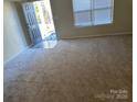 Open living room with carpeted floors and a window at 15200 Chowning Tavern Ln, Charlotte, NC 28262