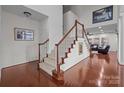 Open foyer featuring hardwood floors, staircase with carpet and wood trim, and views into the living room at 15323 Prescott Hill Ave, Charlotte, NC 28277