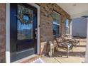 Close-up of the front porch featuring a wreath on the black front door and outdoor seating at 16110 Foreleigh Rd, Huntersville, NC 28078