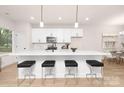 Modern kitchen featuring white cabinetry, stainless steel appliances, and a spacious island with seating at 4811 Victoria Ave, Charlotte, NC 28269