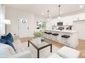 Inviting living room featuring a stylish sofa, island with bar stools, and bright, open kitchen at 4811 Victoria Ave, Charlotte, NC 28269