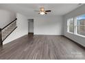 Bright, unfurnished living room featuring hardwood floors, staircase, large windows, and neutral walls at 6148 Durango Way, Denver, NC 28037