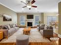 Staged living room featuring a fireplace, hardwood floors, recessed lighting, and ample seating space at 621 Ravenglass Dr, Fort Mill, SC 29715