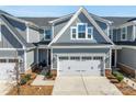 Two-story home with gray siding, brick accents, and a two-car garage with decorative windows at 6278 Ashton Park Dr, Denver, NC 28037