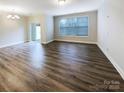 Spacious living room featuring hardwood floors and sliding door access to an outdoor space at 8619 Harris Lake Ln, Charlotte, NC 28269