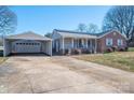 Ranch-style brick and siding home with solar panels, detached garage and long driveway on sunny day at 9026 Longview Dr, Charlotte, NC 28214