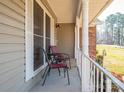 Welcoming front porch featuring chairs, a small table, and a decorative railing at 9026 Longview Dr, Charlotte, NC 28214