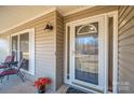 Inviting front porch with a glass door, window, potted flowers and outdoor seating area at 9026 Longview Dr, Charlotte, NC 28214