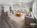 Inviting living room with wood floors, neutral paint, a ceiling fan, and an abundance of comfortable seating at 9645 Hanberry Blvd # 47, Charlotte, NC 28213