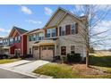 View of the townhome featuring a two-car garage and well-maintained landscaping at 11142 Jc Murray Nw Dr, Concord, NC 28027