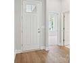 Inviting foyer with hardwood floors and a view into a naturally lit living space at 13134 Macon Hall Dr, Mint Hill, NC 28227
