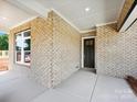 A welcoming brick porch with ample room and covered ceiling with an exterior door at 13134 Macon Hall Dr, Mint Hill, NC 28227