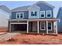 Charming two-story home featuring stone accents, a two-car garage, and a welcoming covered front porch at 13308 Chopin Ridge Rd, Huntersville, NC 28078