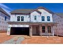 New construction home featuring a covered entry, two-car garage and visible Tyvek HomeWrap at 13308 Chopin Ridge Rd, Huntersville, NC 28078