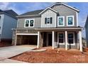 Charming two-story home with gray siding, stone accents, covered entry, and an attached two-car garage at 13308 Chopin Ridge Rd, Huntersville, NC 28078