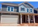 Beautiful two-story home with stone accents, covered porch, and attached two car garage at 13308 Chopin Ridge Rd, Huntersville, NC 28078