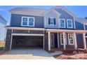 Two-story home featuring stone accents, an attached two-car garage, and a welcoming covered front porch at 13308 Chopin Ridge Rd, Huntersville, NC 28078